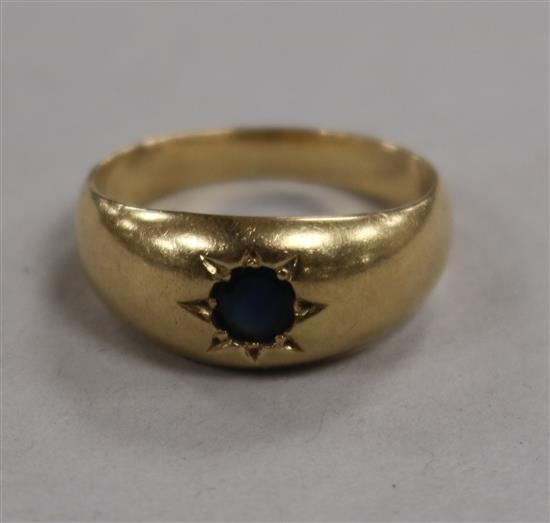 An unmarked gypsy-set ring, inset sapphire (tests as 14K gold) size O.